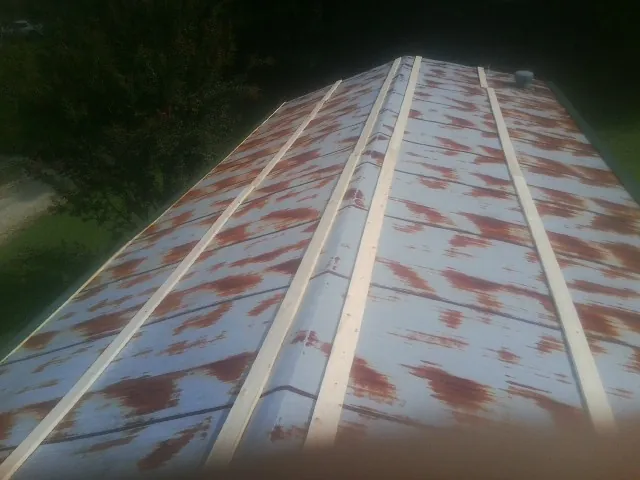 Rusted metal roof panels with new wood purlins before replacement — Storm Damage Roof Repair in Ransom by Roofing Brothers