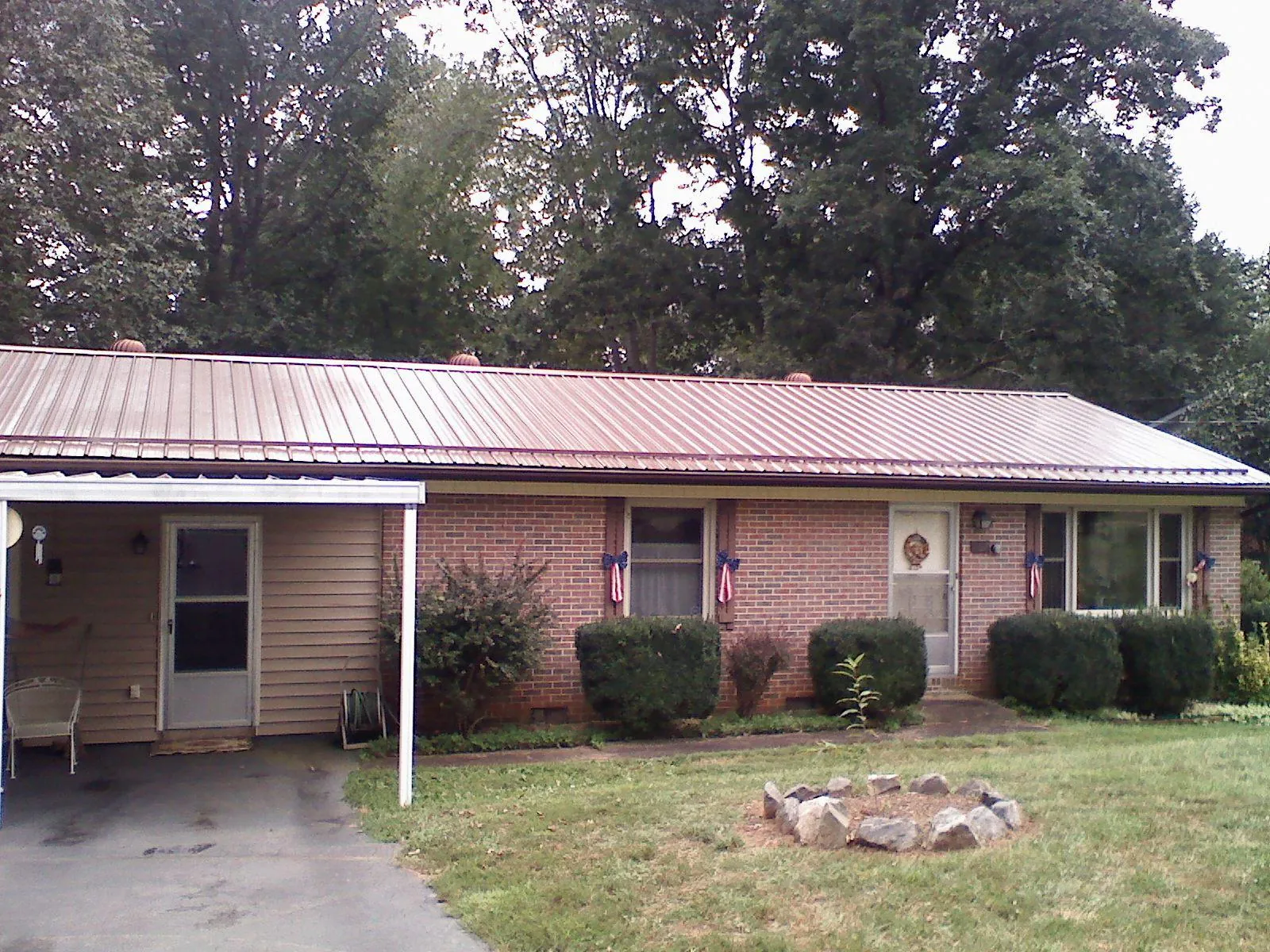 Bronze metal roof and carport on a brick ranch home — Roof Repair work by our crew in Ransom